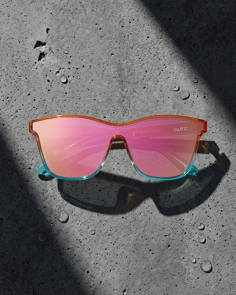 Sunglasses with red lenses and orange colorful frame on a textured black surface